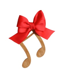 Wooden note with bow on white background. Christmas music concept