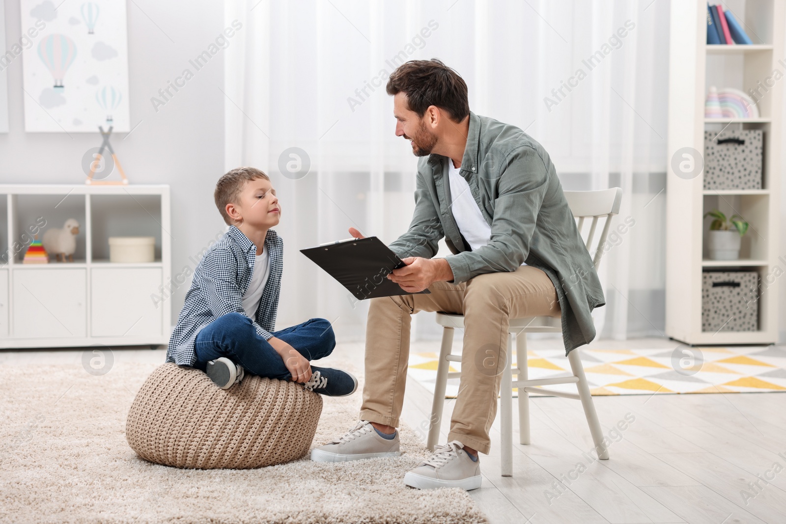 Photo of Dyslexia treatment. Therapist working with boy in room