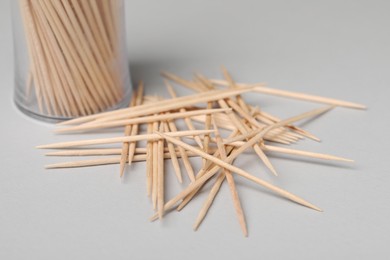 Photo of Disposable wooden toothpicks on grey background, closeup