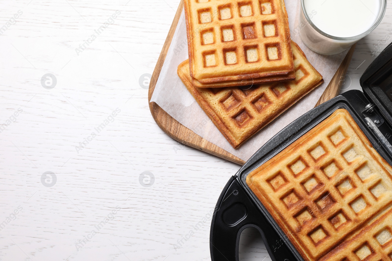 Photo of Flat lay composition with fresh Belgian waffles on white wooden table. Space for text