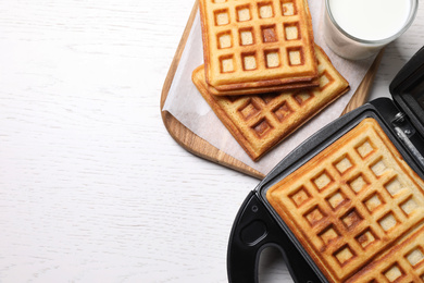 Photo of Flat lay composition with fresh Belgian waffles on white wooden table. Space for text