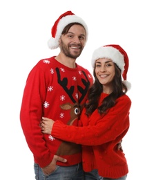 Photo of Young couple in Christmas sweaters and hats on white background