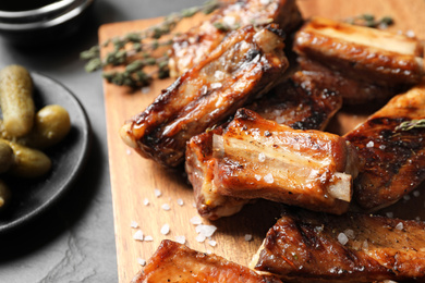 Photo of Delicious grilled ribs served on table, closeup
