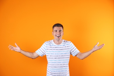 Photo of Handsome emotional young man on color background