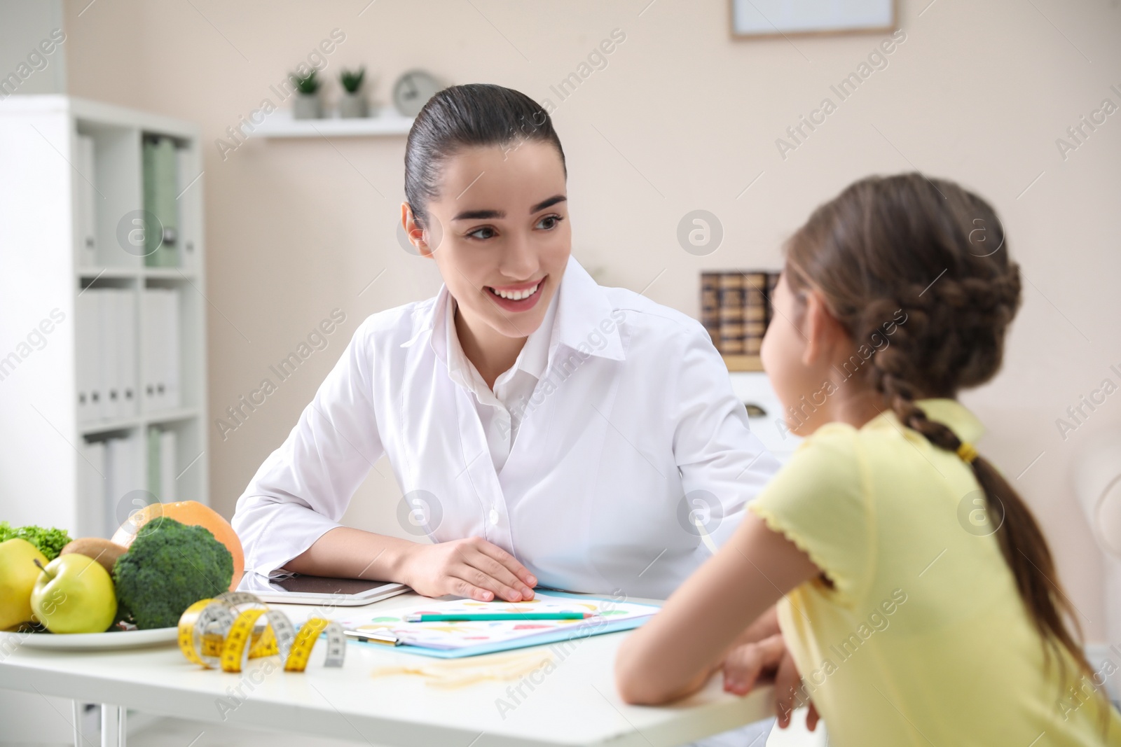 Photo of Little girl visiting professional nutritionist in office