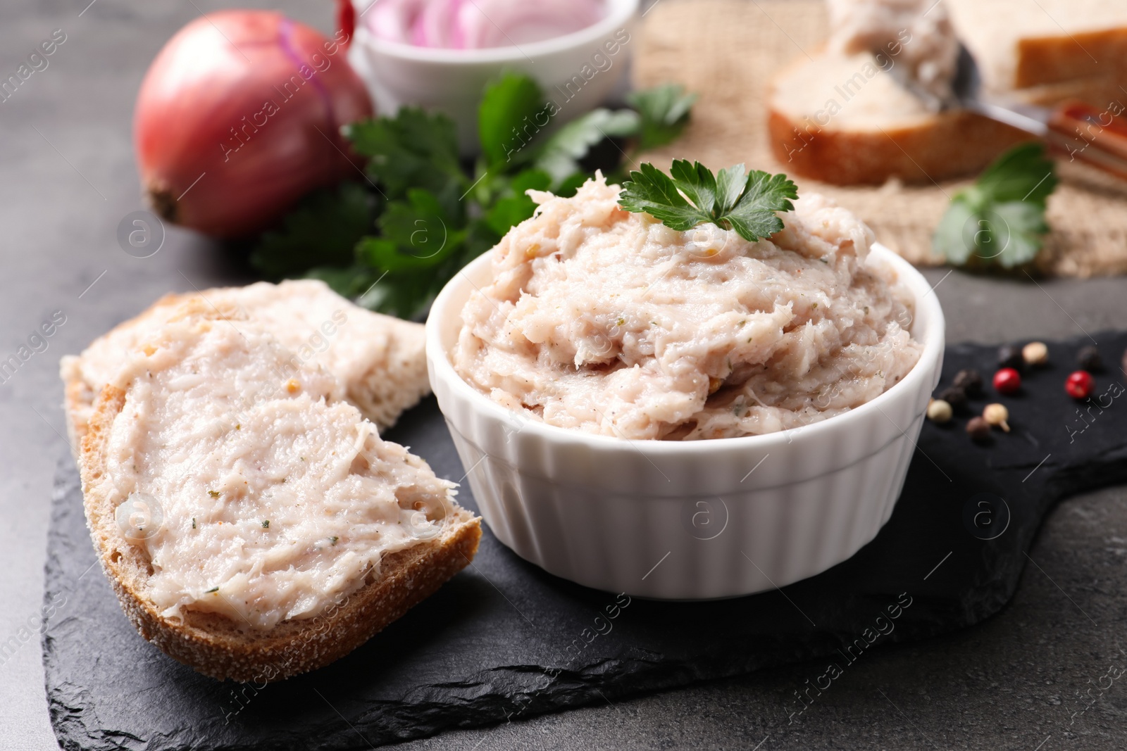 Photo of Delicious lard spread in bowl and sandwich on grey table