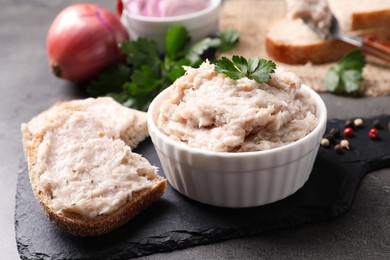 Delicious lard spread in bowl and sandwich on grey table