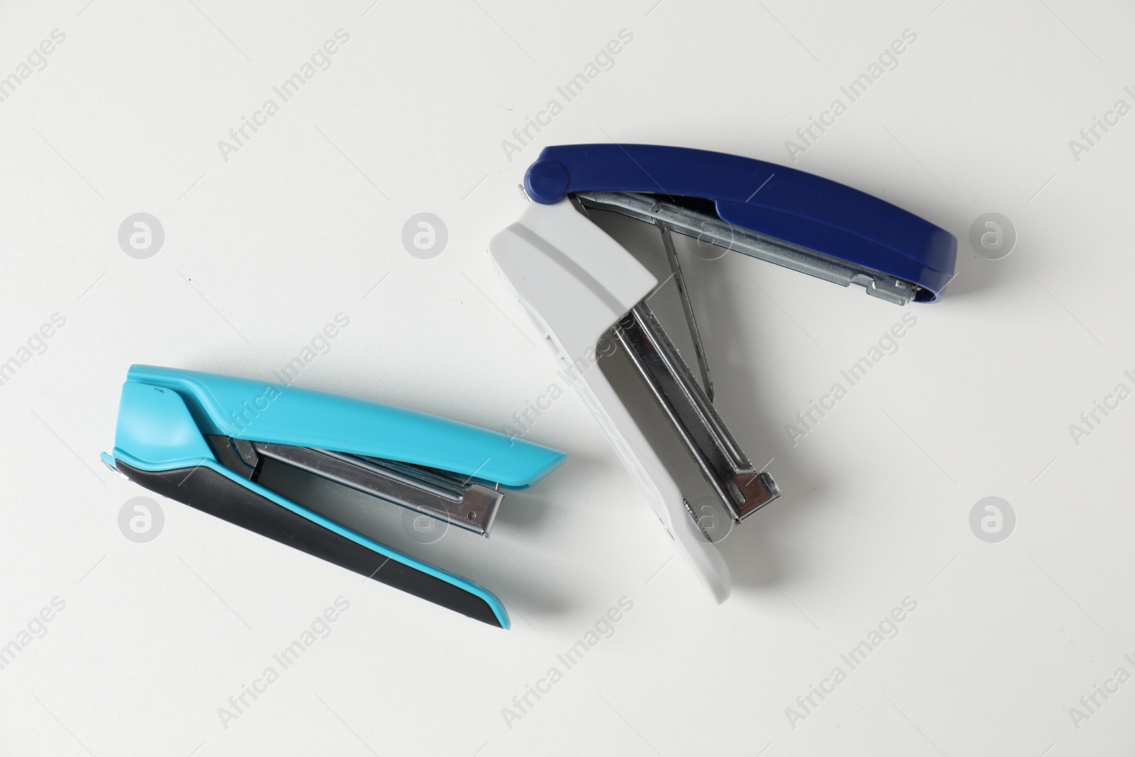 Photo of Color stapler on white table, flat lay