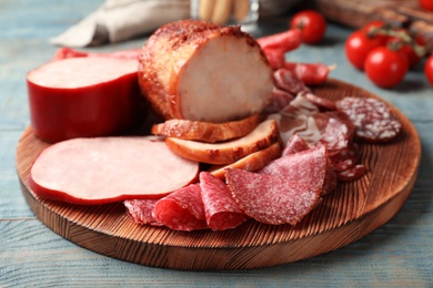 Photo of Cutting board with different sliced meat products served on table