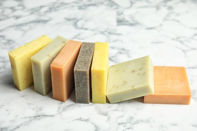 Many different handmade soap bars on marble table