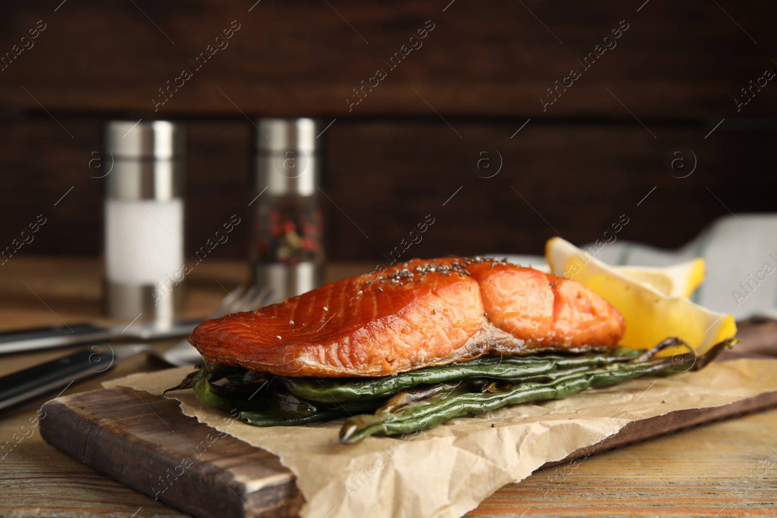 Photo of Tasty cooked salmon and vegetables served on wooden table. Healthy meals from air fryer