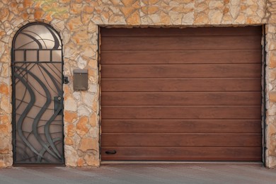 Entrance of garage with sectional door in private house outdoors