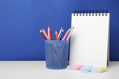 Different school stationery on white table against blue background, space for text. Back to school