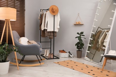 Modern dressing room interior with clothing rack and mirror