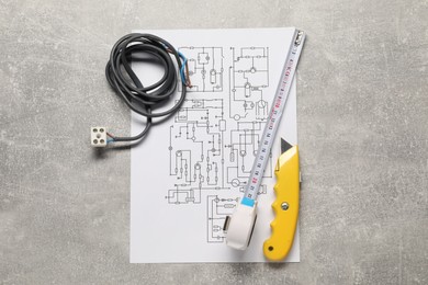 Photo of Wiring diagram, wires and tools on grey table, top view