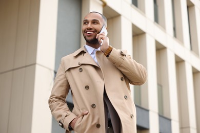 Happy man talking on smartphone outdoors. Lawyer, businessman, accountant or manager