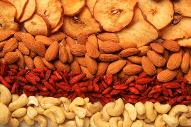 Mix of delicious dried nuts and fruits as background, top view