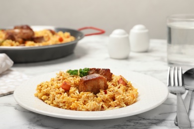 Plate of tasty rice pilaf with meat on table