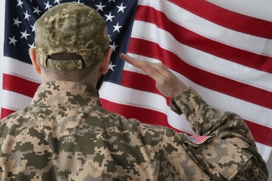 Photo of Soldier in uniform and United states of America flag on white background, back view