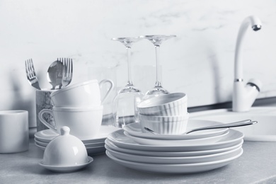 Set of clean dishes and cutlery on kitchen counter