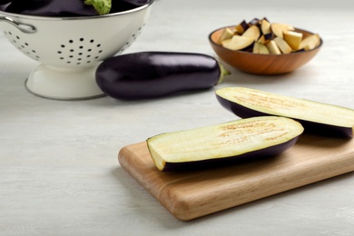 Photo of Wooden board with cut eggplant on table