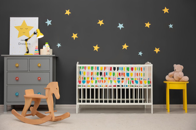 Cute baby room interior with modern crib and rocking horse