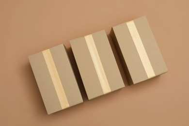 Photo of Cardboard boxes on light brown background, flat lay