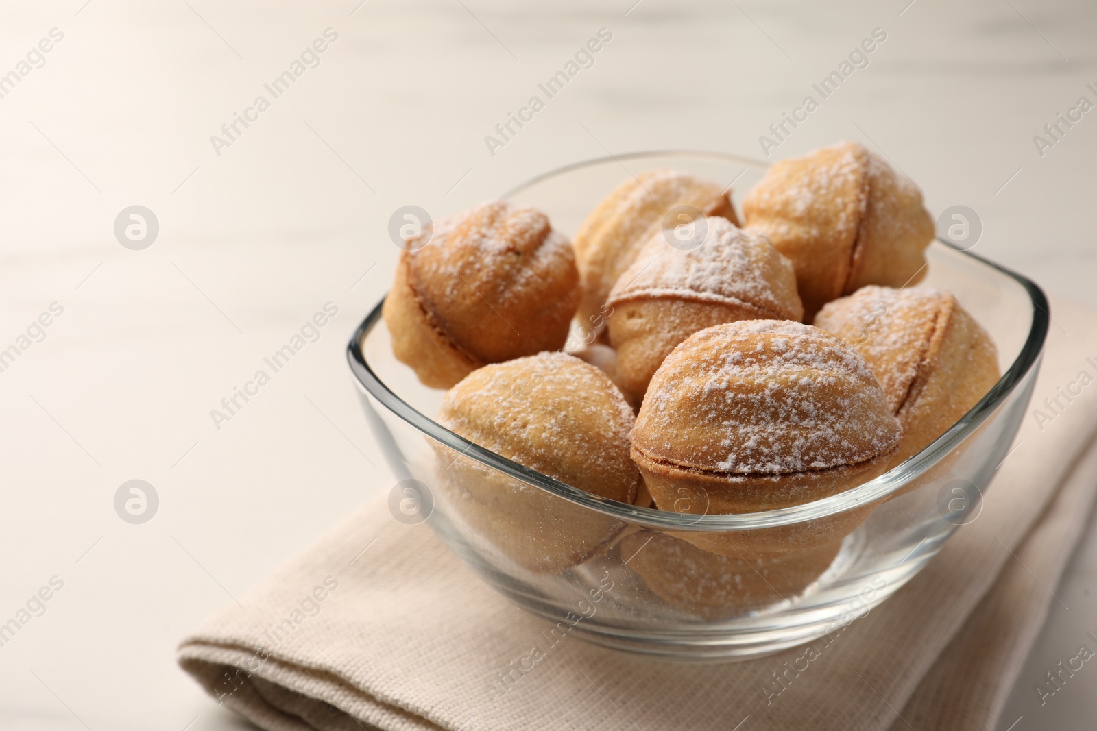 Photo of Homemade walnut shaped cookies with condensed milk on white marble table, closeup. Space for text