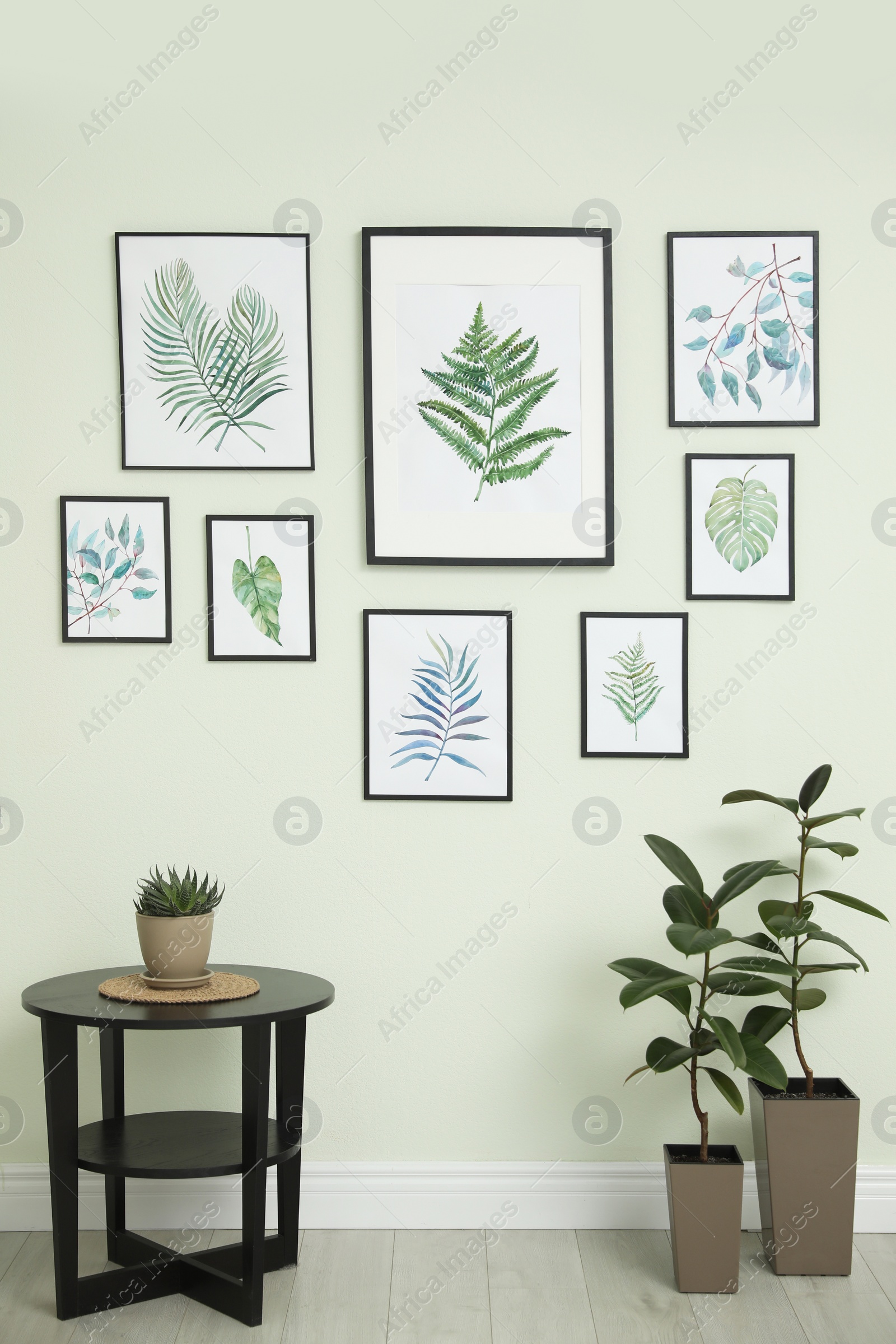 Photo of Living room interior with paintings of tropical leaves on white wall