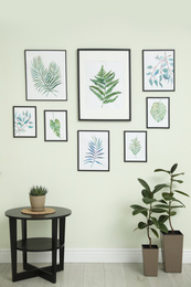 Living room interior with paintings of tropical leaves on white wall