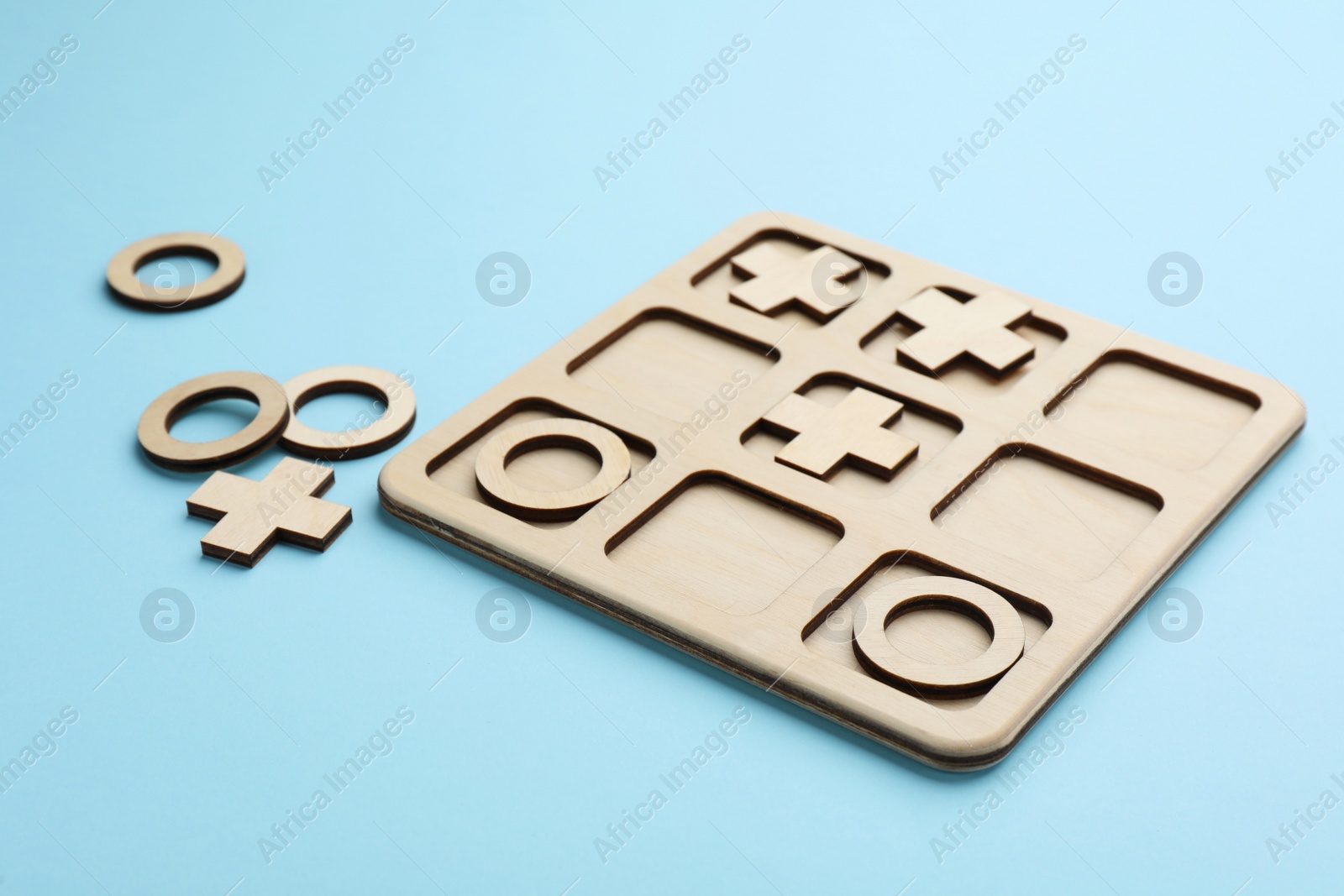 Photo of Tic tac toe set on light blue background