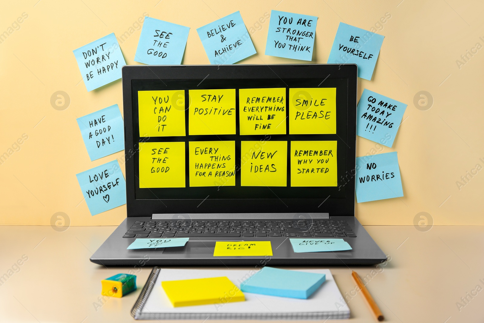 Photo of Paper notes with life-affirming phrases and laptop on table against beige background