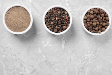 Ground pepper and corns on grey table, flat lay.  Space for text