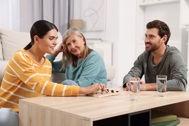 Photo of Family playing checkers at coffee table in room