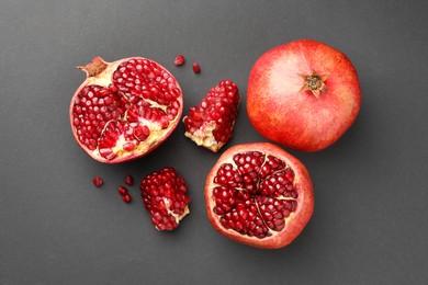 Photo of Fresh ripe pomegranates on grey background, flat lay