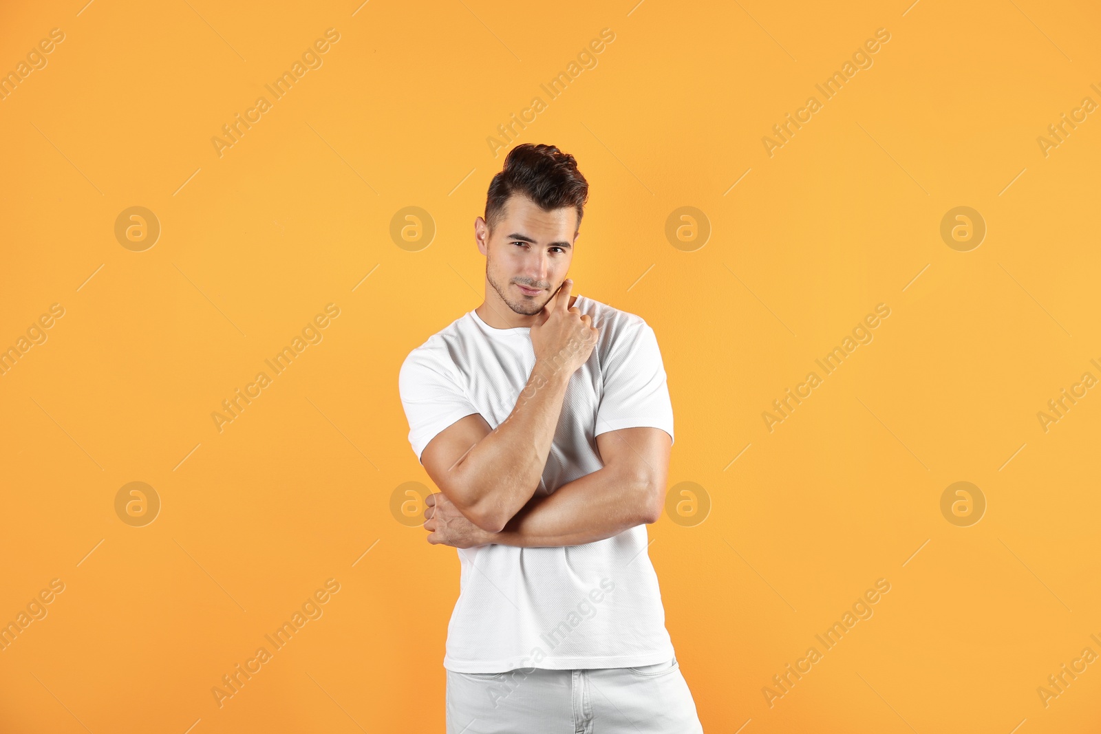 Photo of Young man in stylish jeans on color background