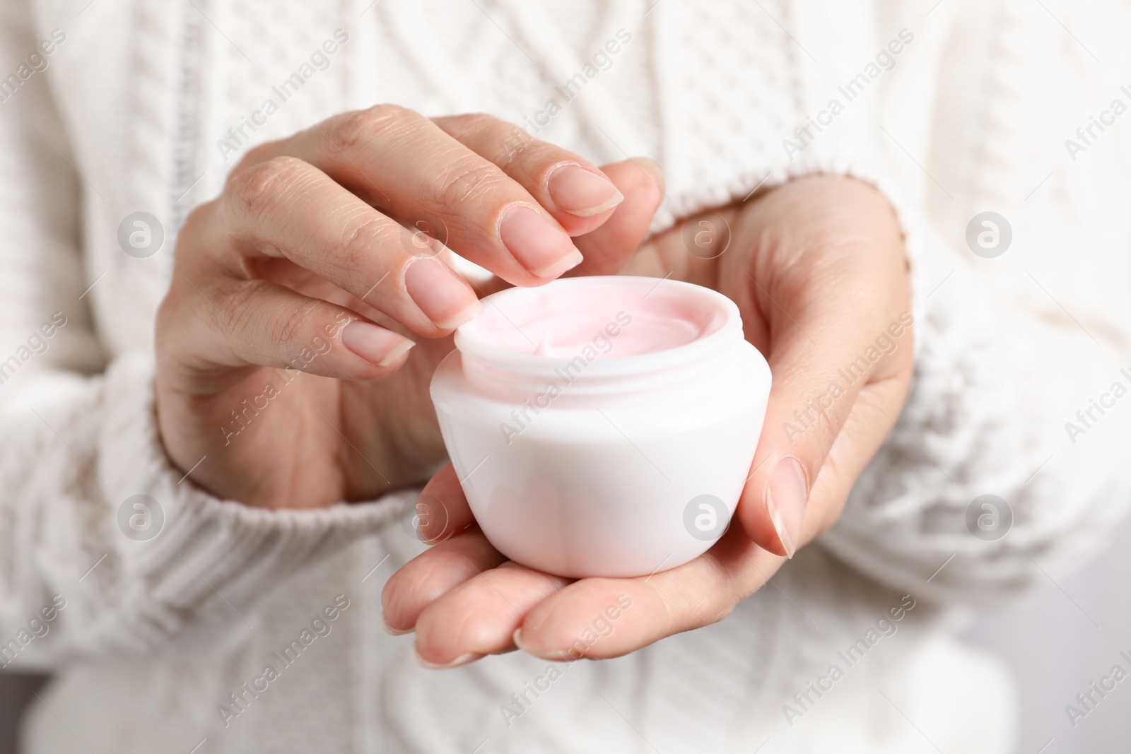 Photo of Woman holding jar of moisturizing cream, closeup. Winter skin care cosmetic