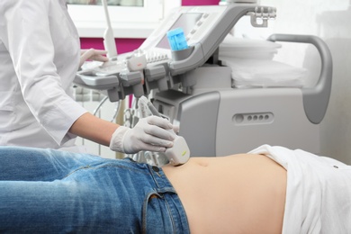 Doctor conducting ultrasound examination of internal organs in clinic, closeup