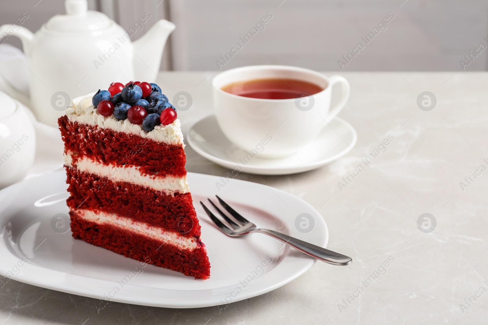 Photo of Plate with piece of delicious homemade red velvet cake on table. Space for text