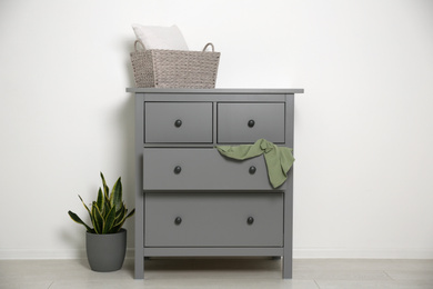 Photo of Grey chest of drawers near light wall