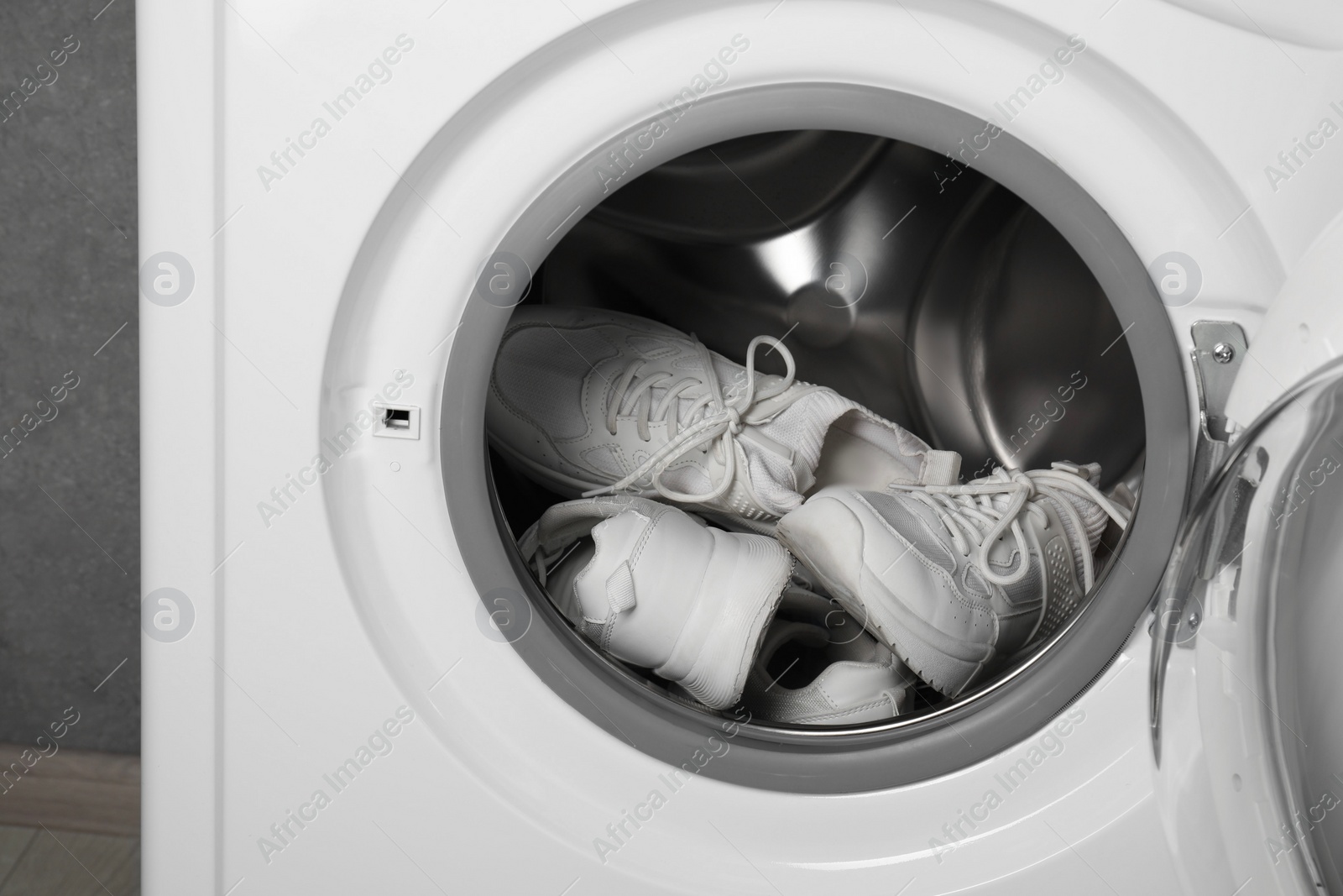 Photo of Stylish clean sneakers inside modern washing machine