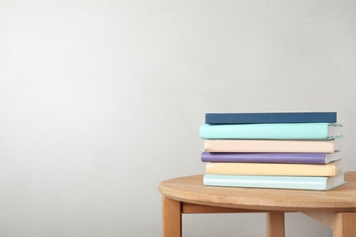 Photo of Stack of books on table against light background. Space for text