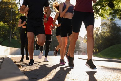 Photo of Group of people running outdoors on sunny day, closeup
