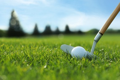 Photo of Hitting golf ball with club on green course, closeup. Space for text