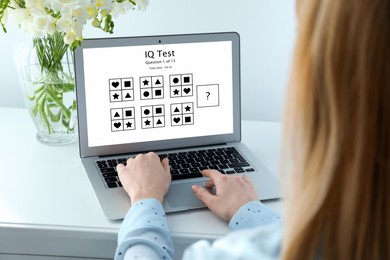 Image of Woman using laptop for taking IQ test indoors, closeup