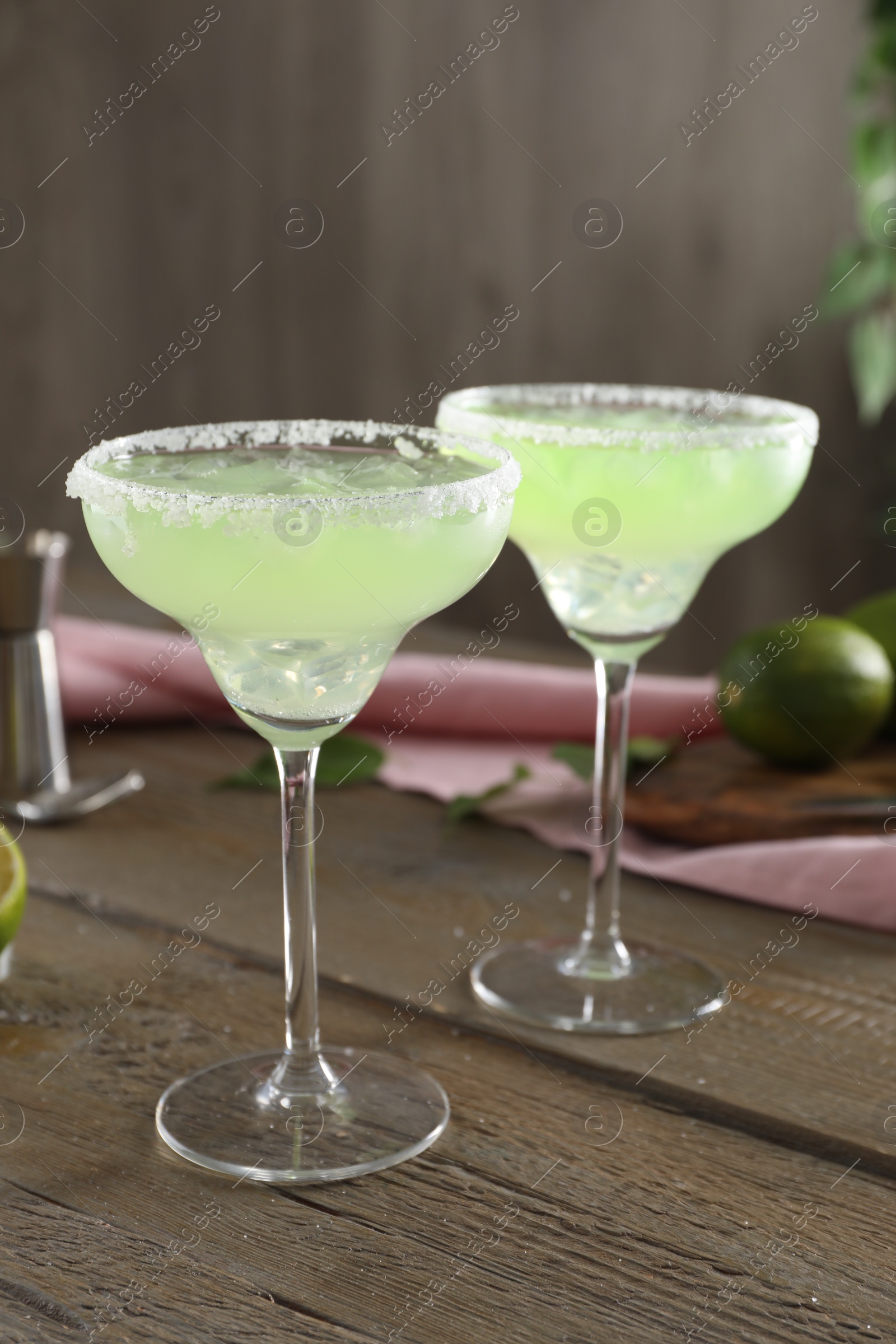 Photo of Delicious Margarita cocktail in glasses on wooden table, closeup