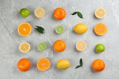 Flat lay composition with tangerines and different citrus fruits on grey marble background