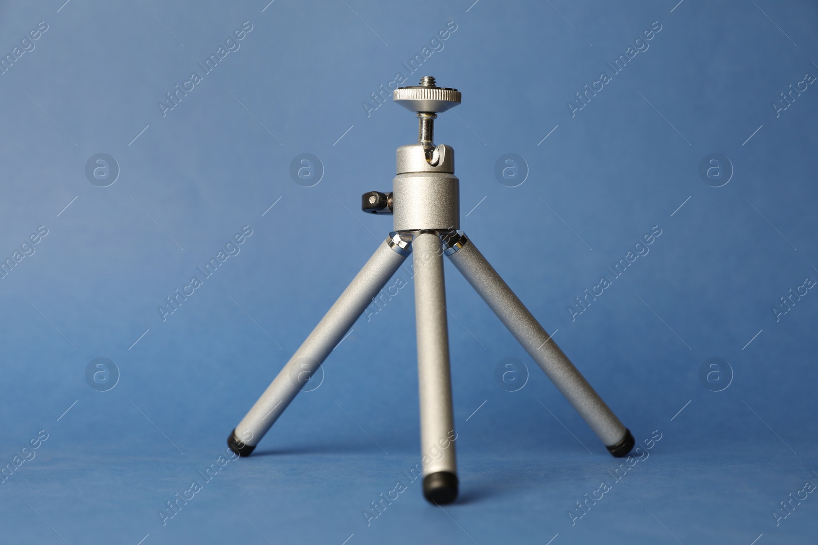 Photo of Modern stylish mobile tripod on blue background