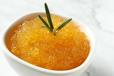 Photo of Fresh pike caviar and rosemary in bowl on white table, closeup