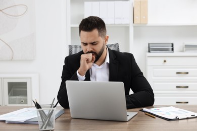 Sick man coughing at workplace in office